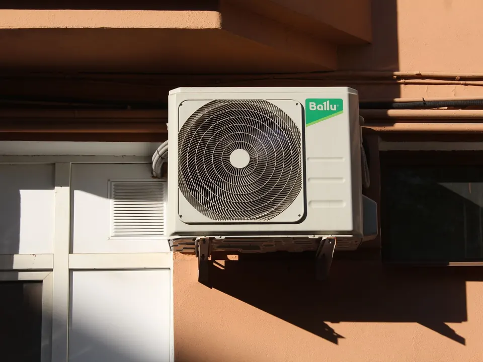 Outdoor condenser unit mounted on a sunny exterior wall